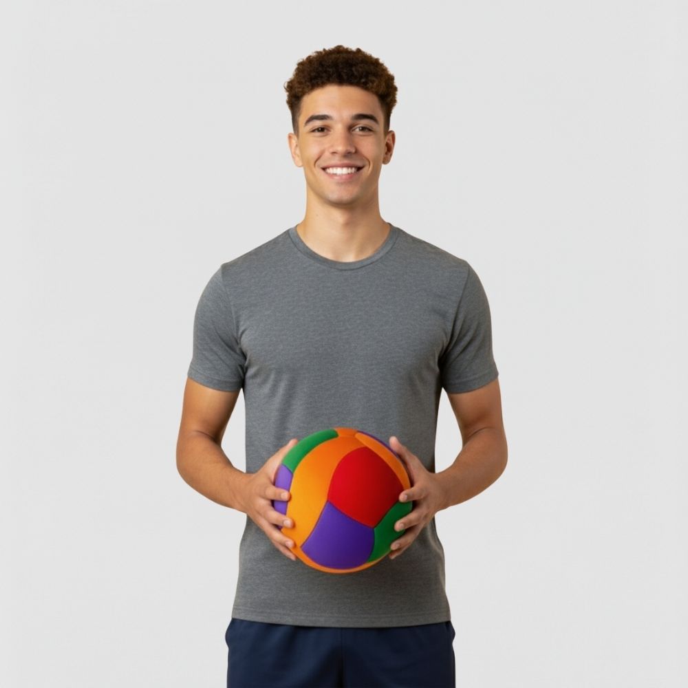 Man holding a colorful ball against a plain background