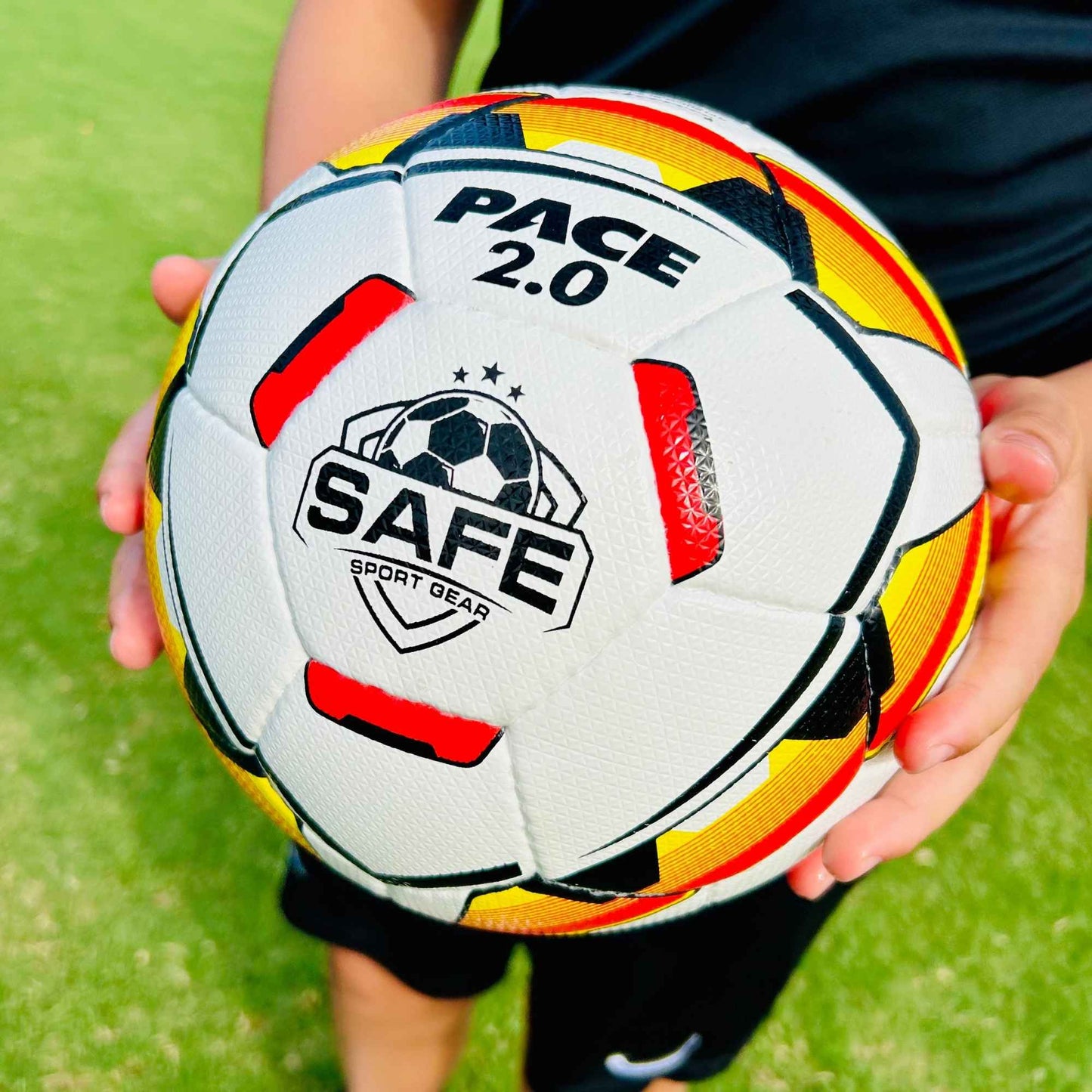 Pace 2.0 Soccer Ball with Safe Sport Gear branding held by a person on a grassy field.