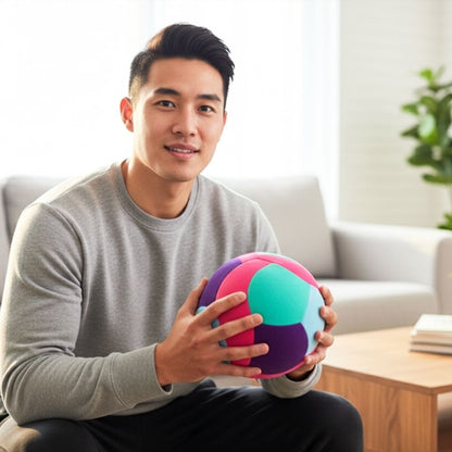 Man holding a Softy Volleyball-Teal in a living room setting