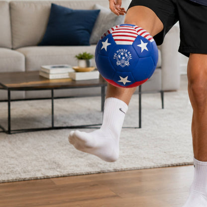 Person kicking a House Ball - USA with white stars in a living room.