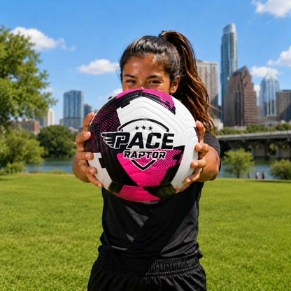Person holding a Pace Raptor Size 5 Soccer Ball - Pink with a city skyline in the background