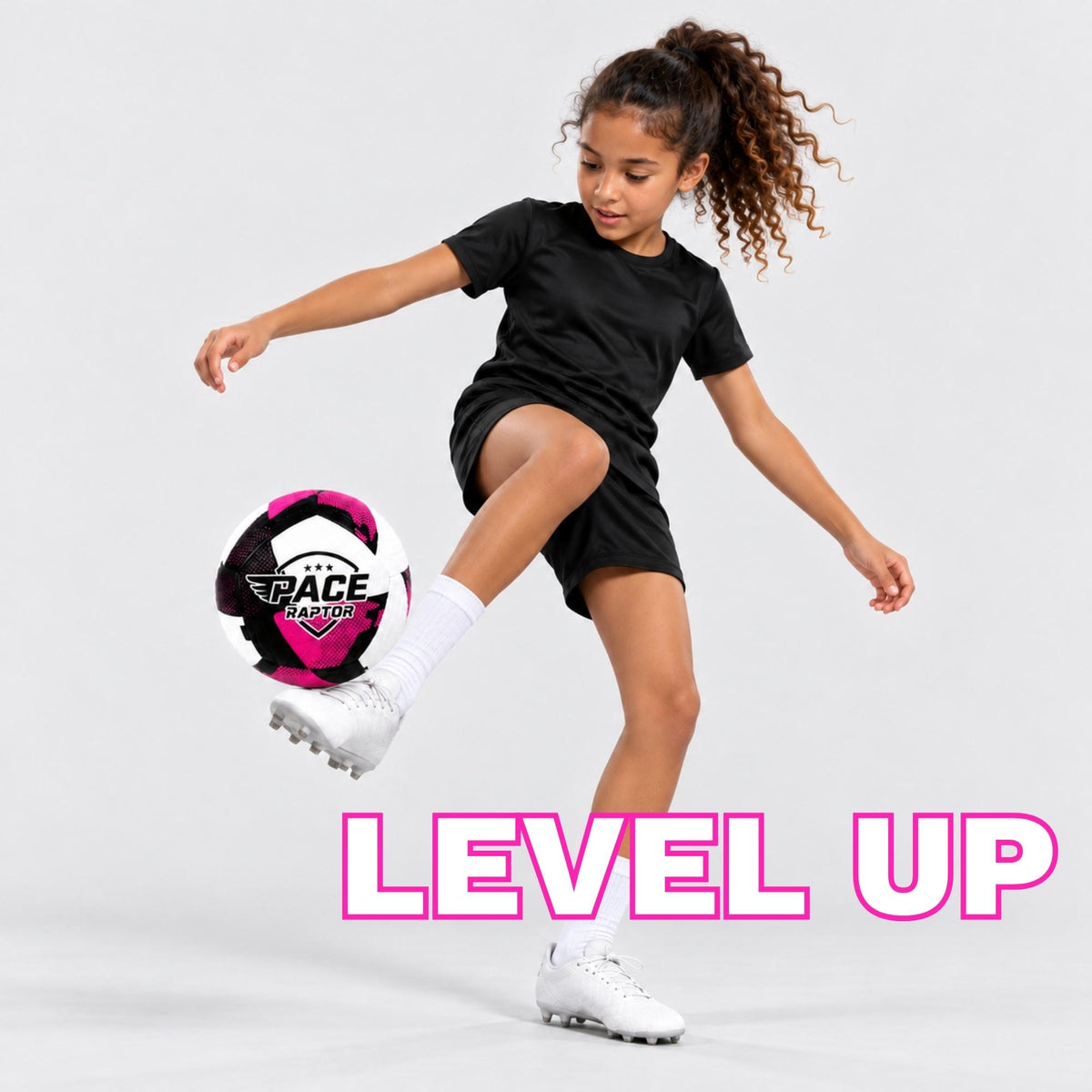 A young girl in a black soccer uniform kicks a black, purple, and white pace raptor soccer ball against a light gray studio background. The text 'LEVEL UP' is displayed in large pink letters at the bottom.