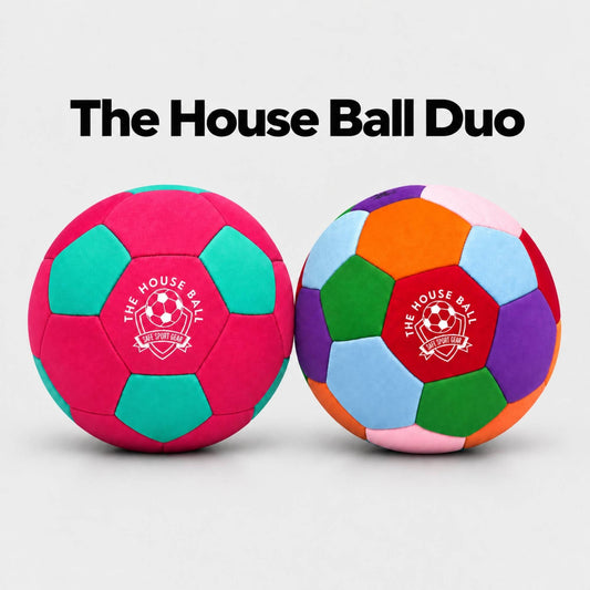 Two colorful house balls on a light gray background with the text 'The House Ball Duo' above them. The left ball is a Pink House Ball, and the right ball is the original House Ball with a red center panel featuring the white 'Safe Sport Gear' logo.